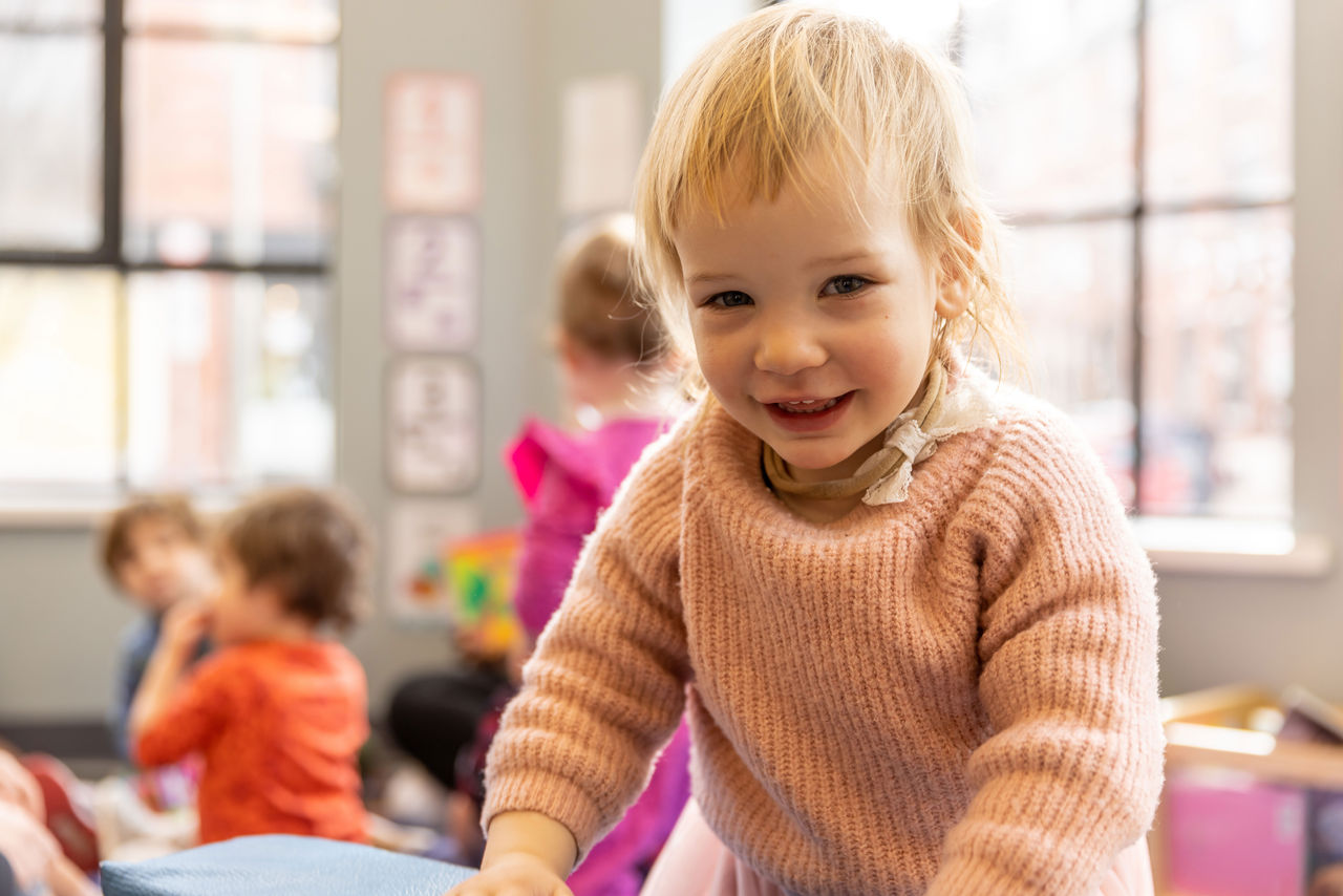 Small child smiling in a classroom