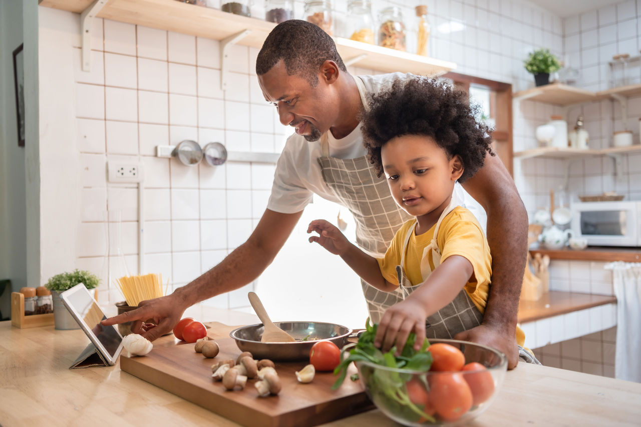 A father and son cooking a recipe together in the kitchen