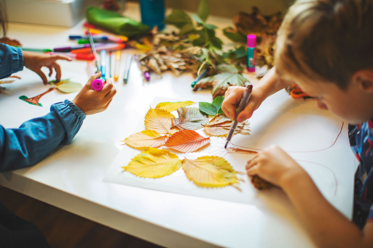 Children creating fall crafts with leaves