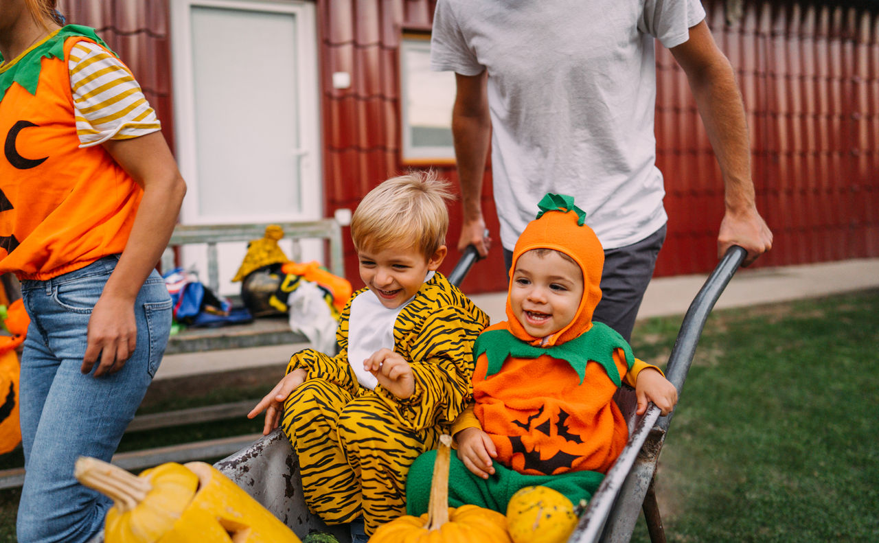 Children in Halloween costumes riding in a wagon trick-or-treating