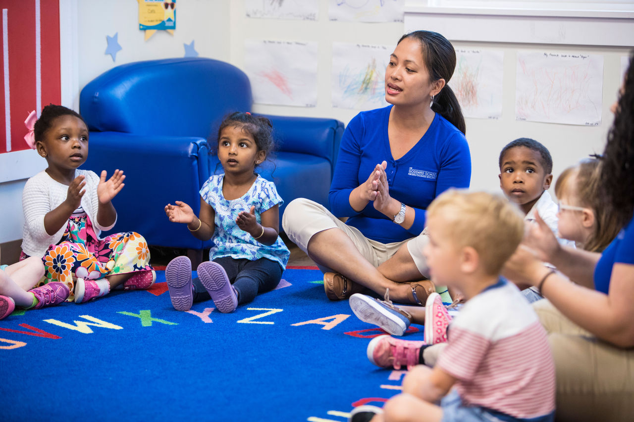 Children clapping in circle time with teachers