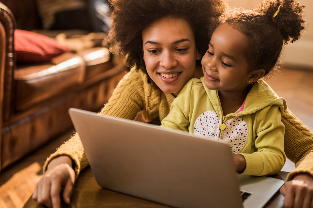 A mother and child looking at a laptop together