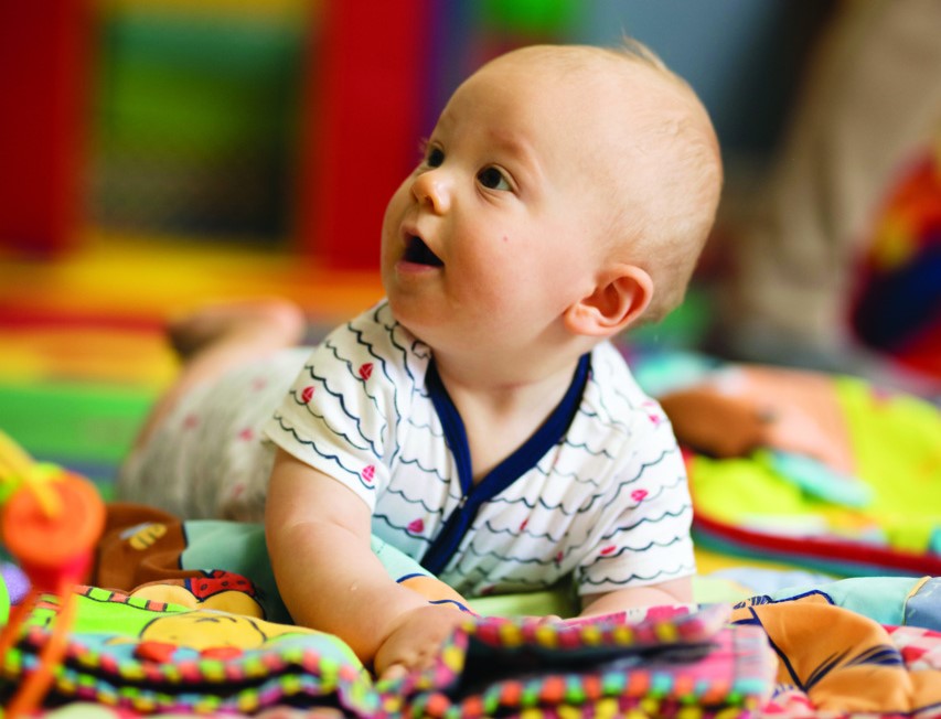 Baby enjoying tummy time in a soft, colorful play mat