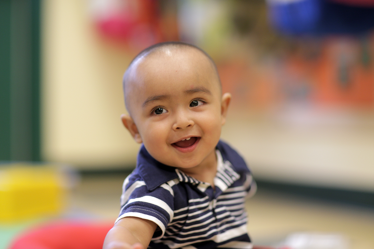 A baby smiling in a classroom